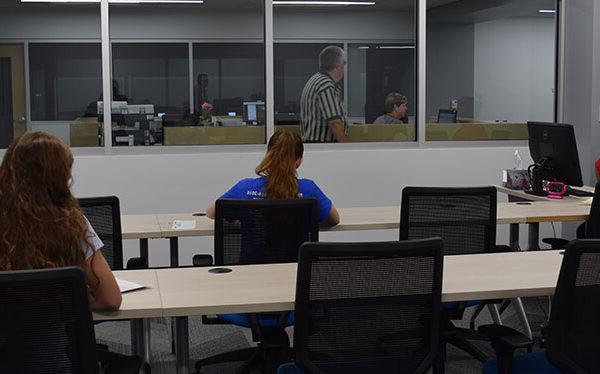 People sitting at tables in a room, testing for current students